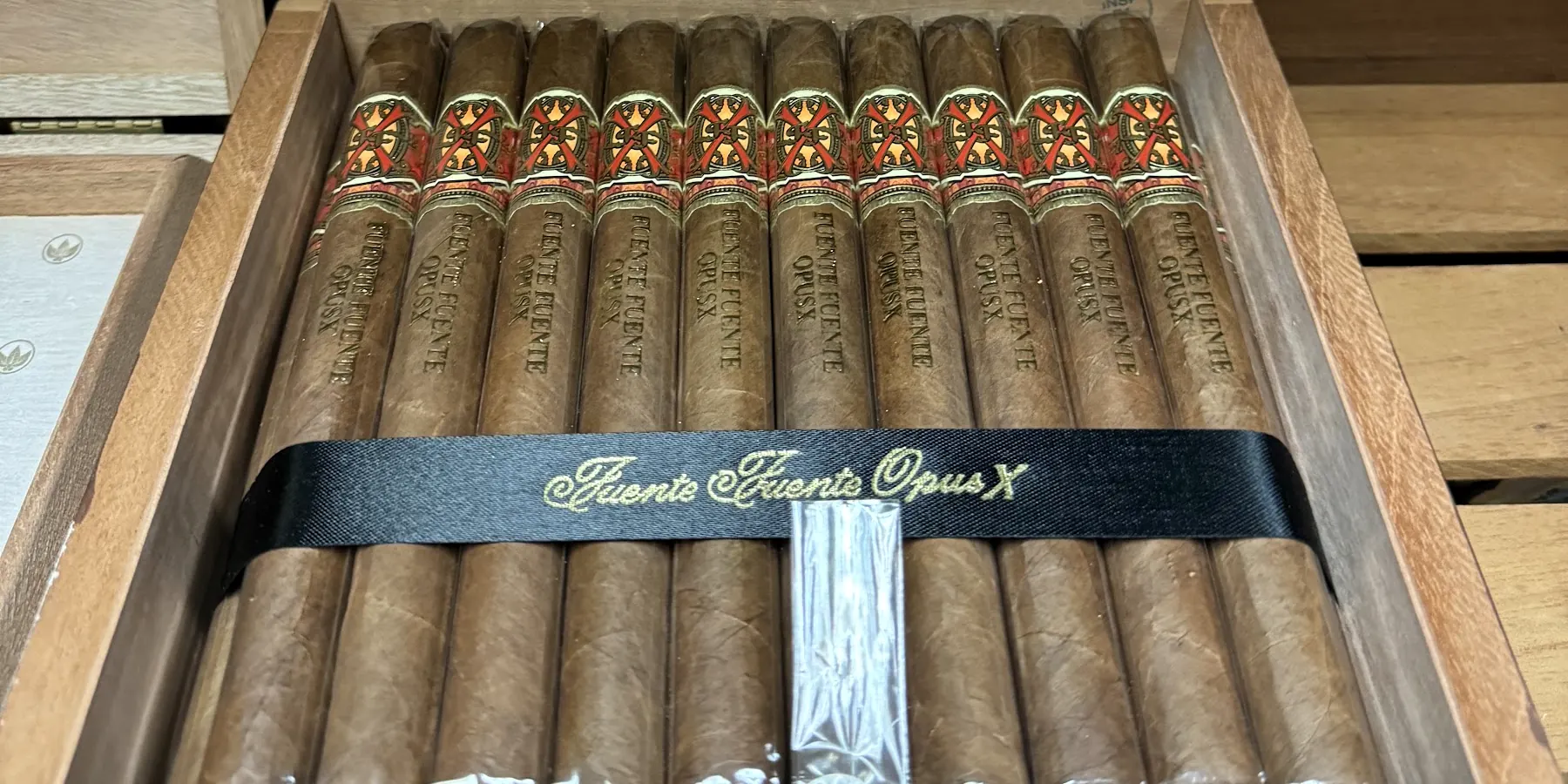 A row of Fuente Fuente OpusX cigars in their cedar box