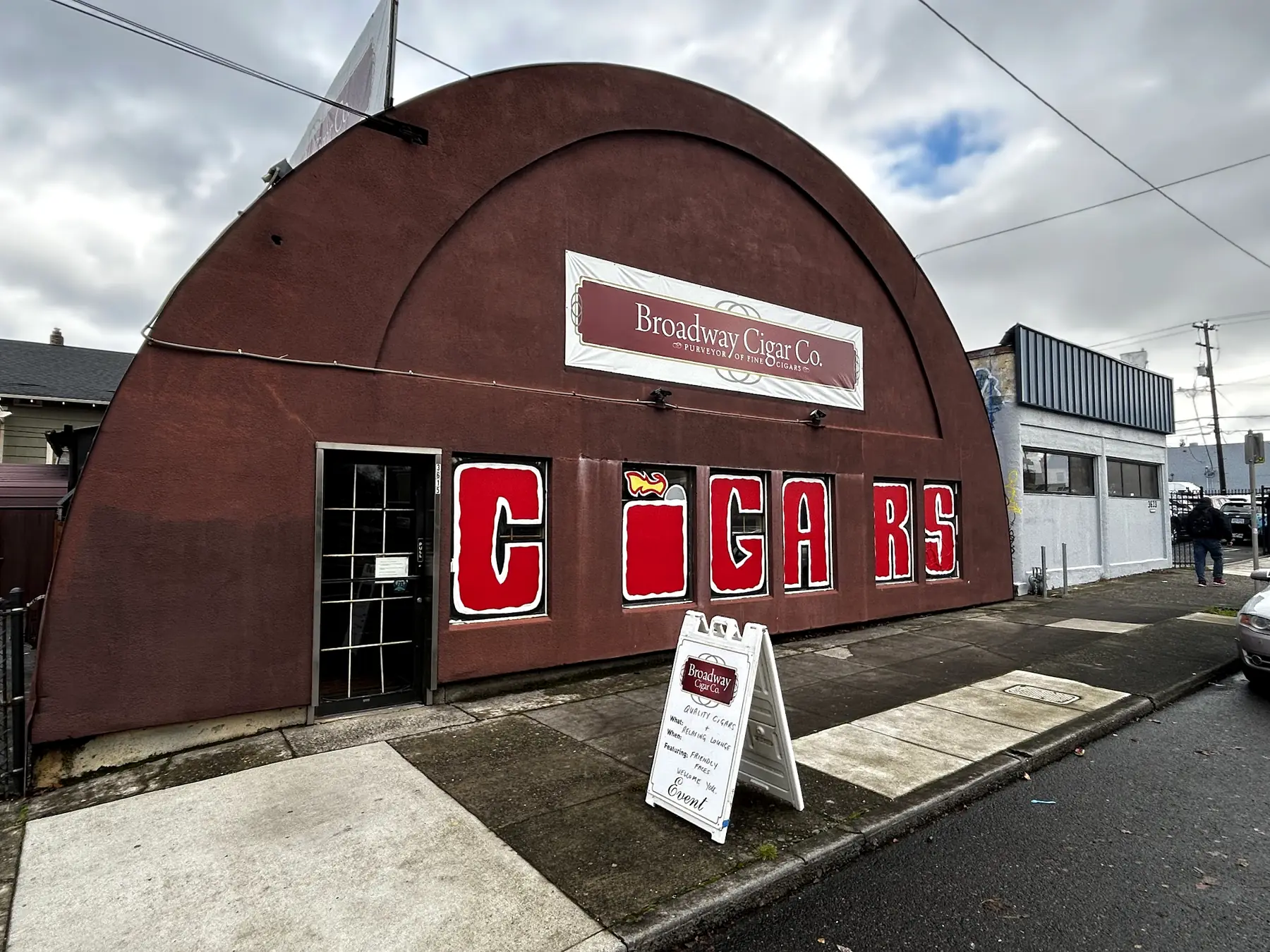 The arched Broadway Cigar Co. storefront with the red CIGARS sign